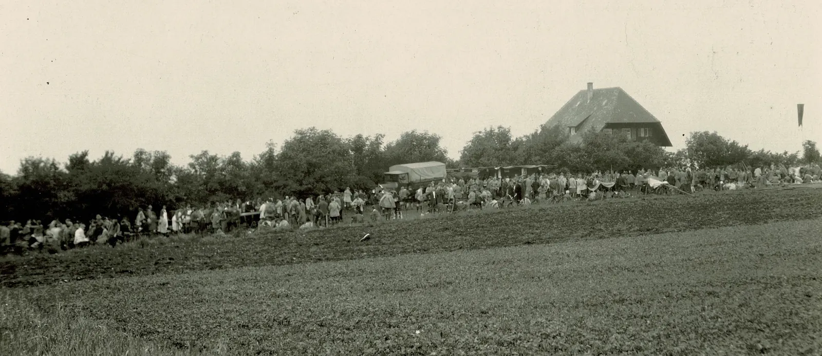 Menschenmenge auf der Wiese vor dem Haus